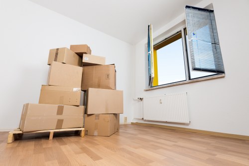 Two movers handling furniture loading on a residential street in Brondesbury